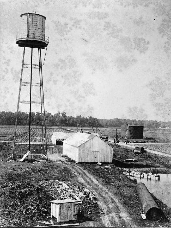 Laurel Valley Sugar Plantation, Thibodaux Louisiana Looking NW at water tower with mill pond and pump house in right center foreground; fuel oil storage tank in right background 1906