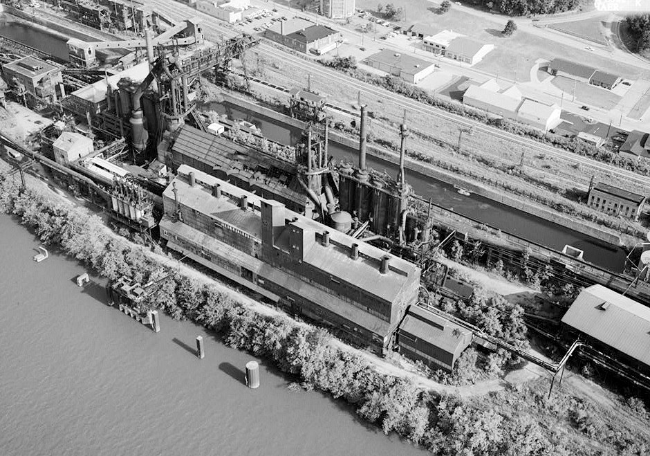 Pittsburgh Steel Company Monessen Works, Monessen Pennsylvania 1995 AERIAL VIEW OF SINTERING PLANT CONVEYORS, BLOWING ENGINE HOUSE, ORE YARD, BLAST FURNACE 1 & 2 & SHARED CAST HOUSE, & CENTRAL STEAM PLANT (LEFT TO RIGHT).