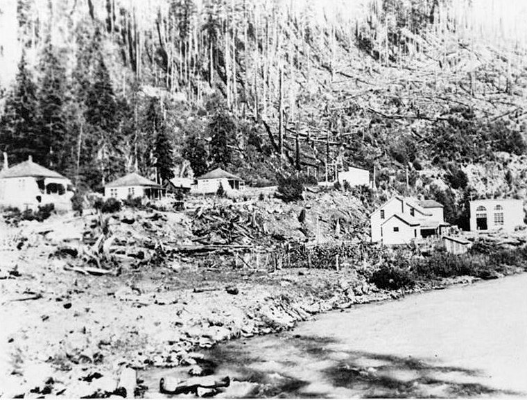 Nooksack Falls Hydroelectric Plant, Glacier Washington Historic view of north facade of hotel (left), and attached garage; picket fence in foreground extends around one of the company houses; looking south. (Photographer unknown, ca. 1906.)