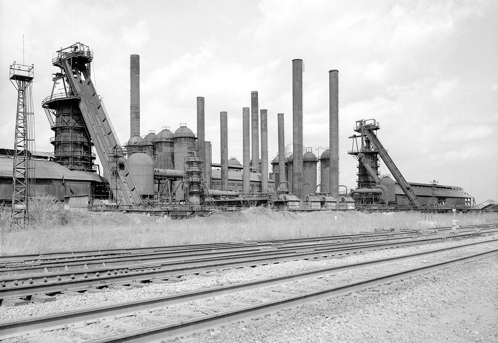 Sloss Furnace - Sloss-Sheffield Steel & Iron Company, Birmingham Alabama 1974 VIEW FROM THE SOUTH OF THE #2 BLAST FURNACE AND CASTING- SHED ON THE LEFT,_IHE #1 BLAST FURNACE AND CASTING SHED ON THE RIGHT, AND THE STOVES, BOILERS, AND AUXILIARY EQUIPMENT IN THE CENTER.