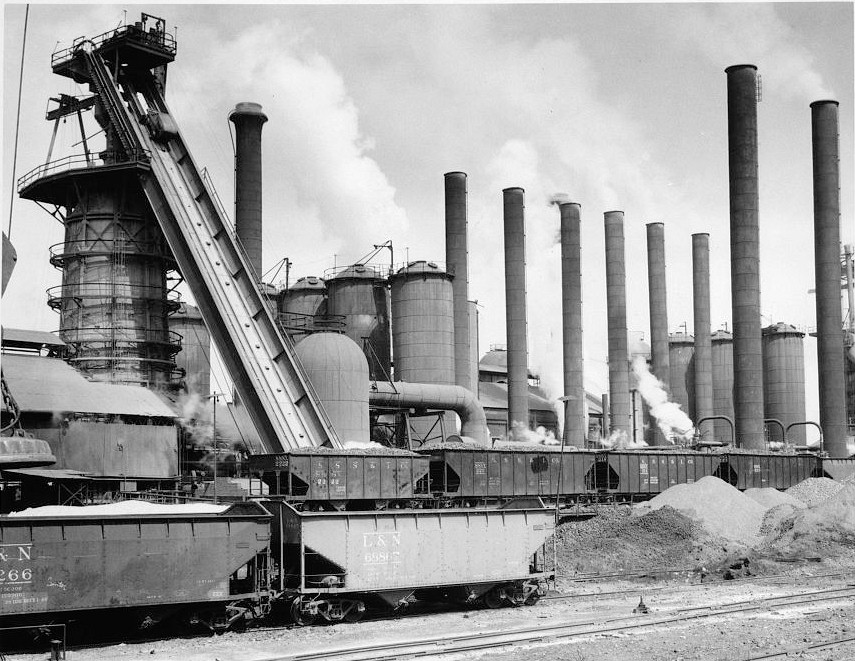 Sloss Furnace - Sloss-Sheffield Steel & Iron Company, Birmingham Alabama 1951 View (when furnaces were still in blast) looking north at central furnace complex with railroad cars of furnace charging materials in foreground and No. 2 Furnace at left.