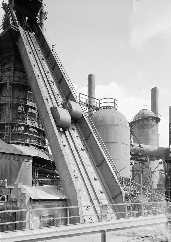 Sloss Furnace - Sloss-Sheffield Steel & Iron Company, Birmingham Alabama 1977 View from southwest of No. 2 Furnace skip-hoist with skip-hoist engine house in left corner and dust catcher in background