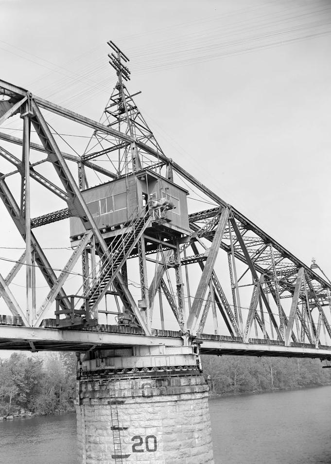 Bridgeport Swing Span Railroad Bridge, Bridgeport Alabama 1980 Showing partial side view of swing bridge in open position. The operator's house is in the center of the truss bridge, directly over the center/pivot stone masonry pier. Note the two (2) center supports with the truss loads being delivered to the drum by a system of distributing girders. The swing bridge revolved on a cylindrical drum supported by rollers running on a circular track on the center/pivot pier.