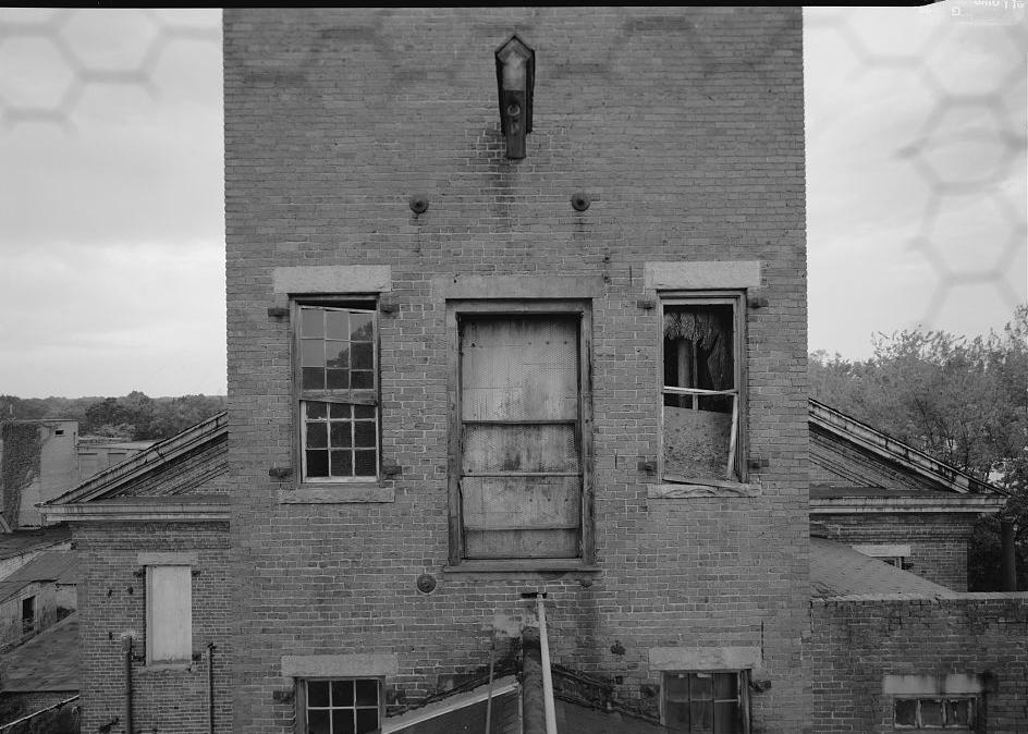 Prattville Manufacturing Company - Cotton Mill, Prattville Alabama FACING WEST FROM ATTIC LEVEL IN MILL NO. 1 TOWER, LOOKING TOWARD MILL NO. 2 WITH HOIST IN VIEW. NOTE LINTEL AND CORNICE DETAILING (1998)