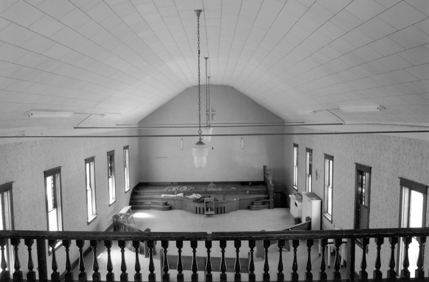 First Presbyterian Church, West Bend Iowa View of the sanctuary looking to the west from the balcony. From this view the shape of the roof, the variation in the window glazing, and the form of the dais are clearly visible. Also note that the hanging light fixtures and the trim (including the railing of the balcony) date to the 1915 renovation (2009)