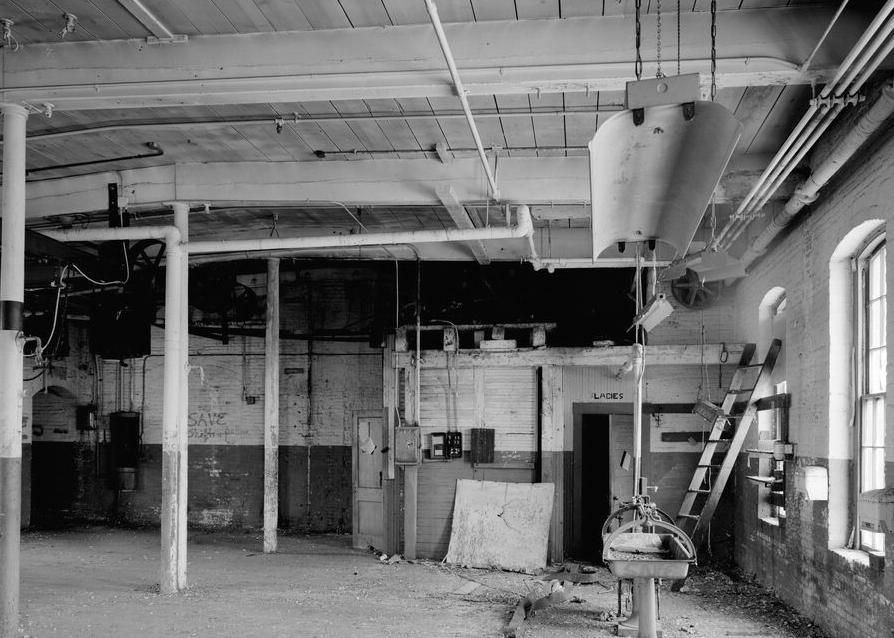 Boston Manufacturing Company, Waltham Massachusetts 1979 TOP FLOOR OF 1816 MILL LOOKING EAST ALONG SOUTH WALL; INTERNAL ELEVATOR HOUSING AND MECHANISM AT REAR.