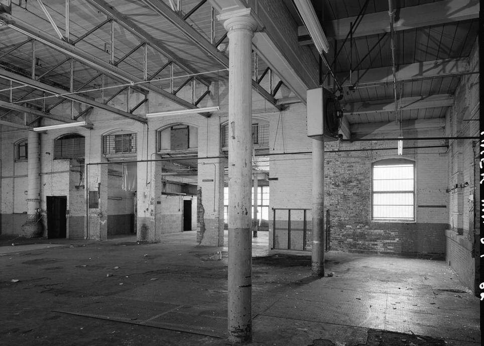 Boston Manufacturing Company, Waltham Massachusetts 1979 1901 STEAM ENGINE HOUSE LOOKING SOUTH THROUH TO 1902 STEAM TURBINE ROOM COLUMNS SUPPORT TRUE EXTERIOR WEST WALL OF THE BUILDING. PORTION TO RIGHT OF COLUMNS IS A LOWER CONNECTOR BETWEEN THE ENGINE HOUSE AND THE 1873 WING.