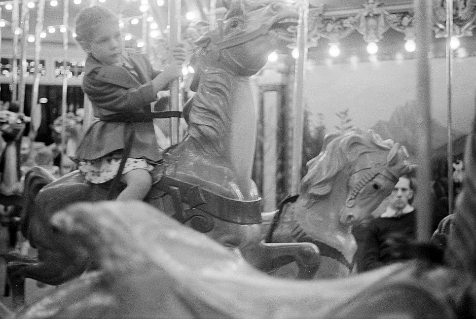 Glen Echo Amusement Park, Glen Echo Maryland A small girl enjoying a ride on the merry-go-round (1939)