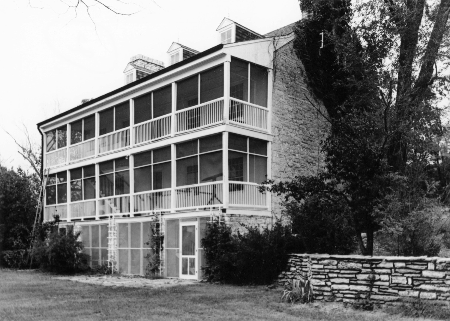 Daniel Boone House, Defiance Missouri Looking north, rear view showing the three-story porch spanning the southwest (rear) wall. There is a curious disagreement in bay module between the basement and the first and second story levels (1969)