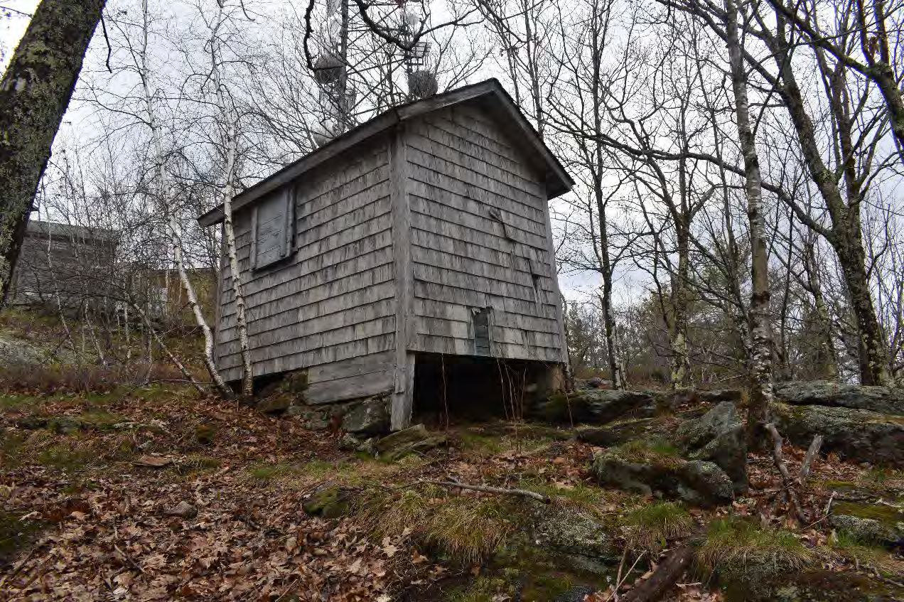 Blue Job Fire Tower, Farmington New Hampshire Storage shed with watchman's cabin and telecommunication buildings behind (2022)