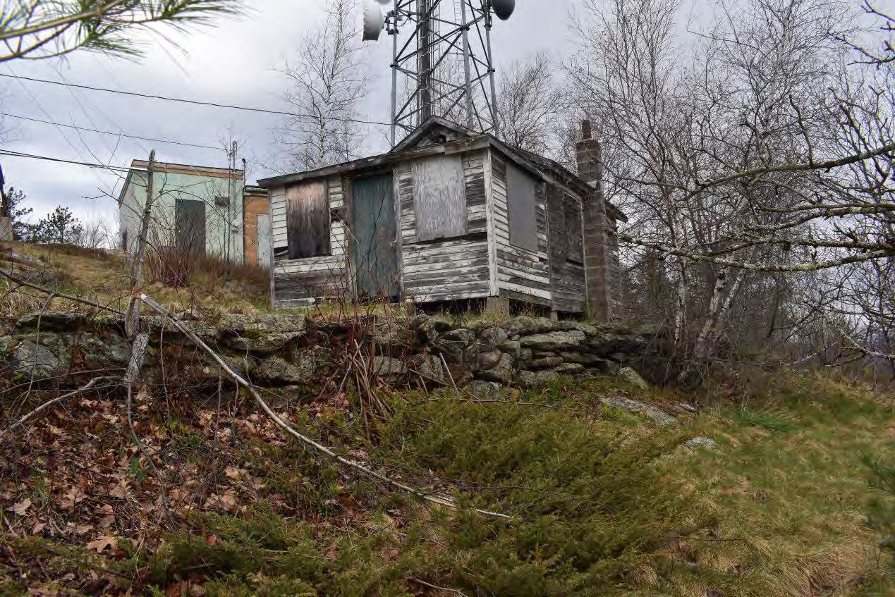 Blue Job Fire Tower, Farmington New Hampshire Retaining wall, watchman's cabin, and telecommunication buildings/tower behind (2022)
