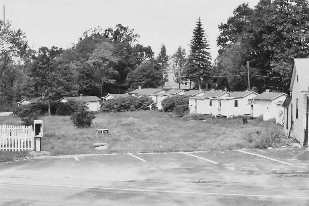 Weirs Highlands Camp and Cottages, Laconia New Hampshire Cabins (G-O) seen across motel parking area and yard (2006)