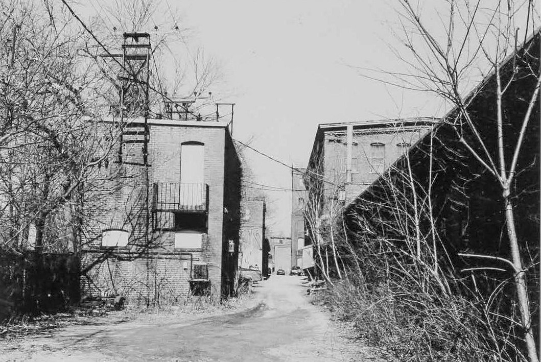 Morley Button Factory, Portsmouth New Hampshire Transformer and storehouse left, looking up former RR siding, 1895 japanning room right front (2003)