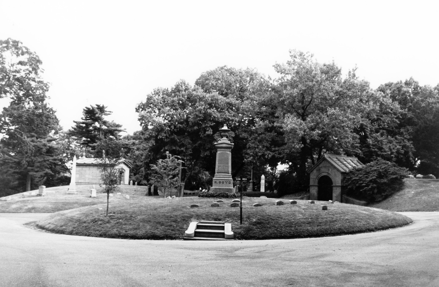 Green-Wood Cemetery-Greenwood, Brooklyn New York View across the landscaped circle at the intersection of Grove, Ocean and Locust Drives looking toward the Catacombs, a Gothic Revival hillside tomb with an arched entry leading into thirty family crypts, built into the adjacent topography (2005)