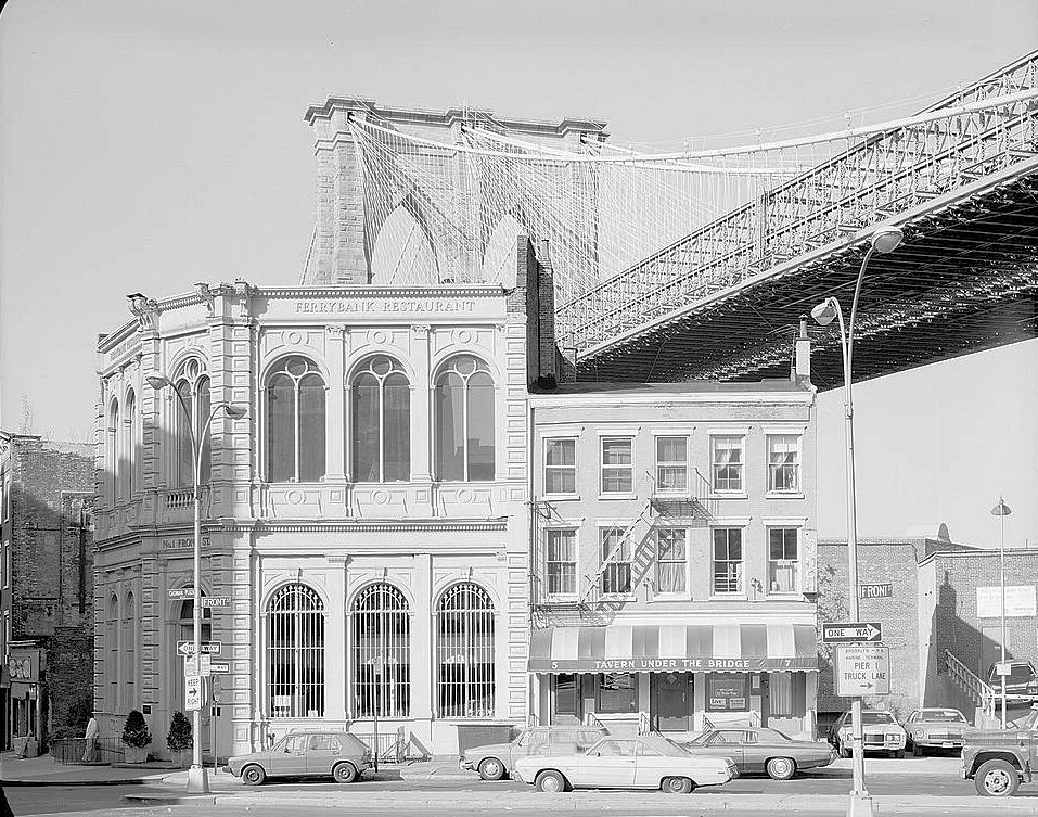 The Brooklyn Bridge, New York New York View of Brooklyn Tower Emerging behind 19Th Century Commercial Buildings on the Corner of Front Street and Camden Plaza (1982)