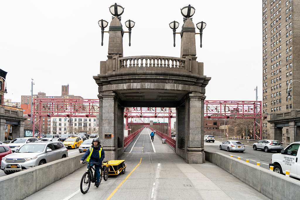 Williamsburg Bridge, New York New York Delivery man riding an electric cargo bike. Manhattan entrance to the Williamsburg Bridge (2021)