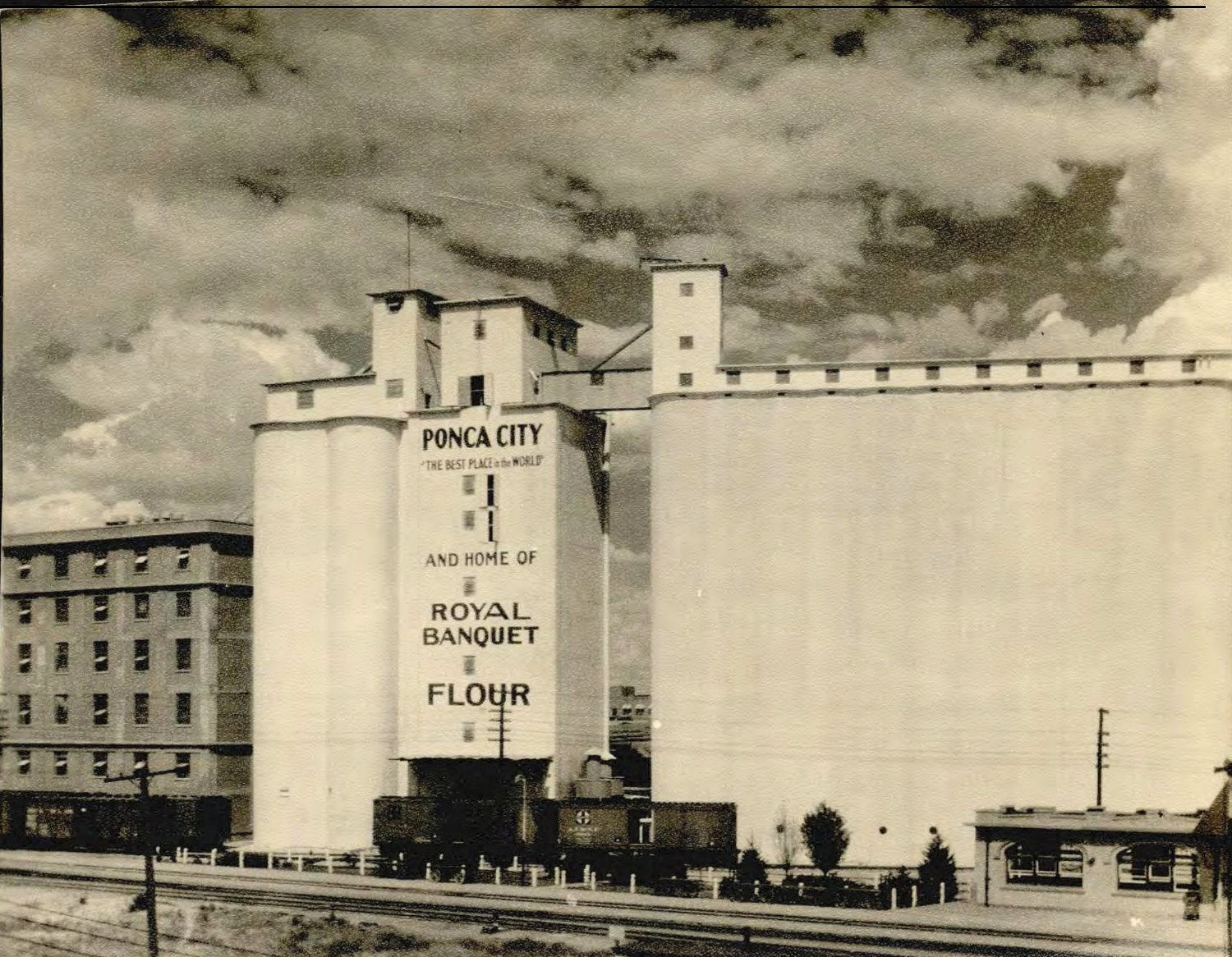 Ponca City Milling Company Elevator, Ponca City Oklahoma This 1930 photo shows the west elevation of the Mill. The mills and train tracks are in full operation here. (1930)