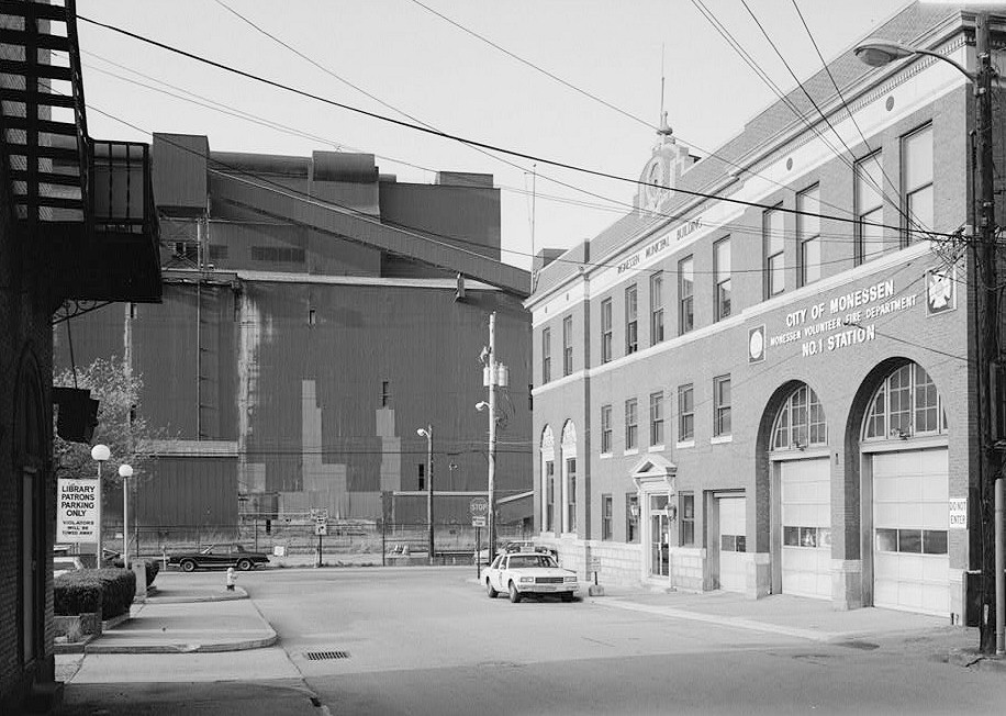 Pittsburgh Steel Company Monessen Works, Monessen Pennsylvania 1991 VIEW LOOKING NORTHWEST FROM NEAR CORNER OF THIRD STREET AND SCHOONMAKER AVENUE, SHOWING BASIC OXYGEN FURNACE BUILDING. THE MONESSEN MUNICIPAL BUILDING (VOLUNTEER FIRE STATION NO. 1), ON THE RIGHT, STANDS AT THE CORNER OF THIRD AND DONNER