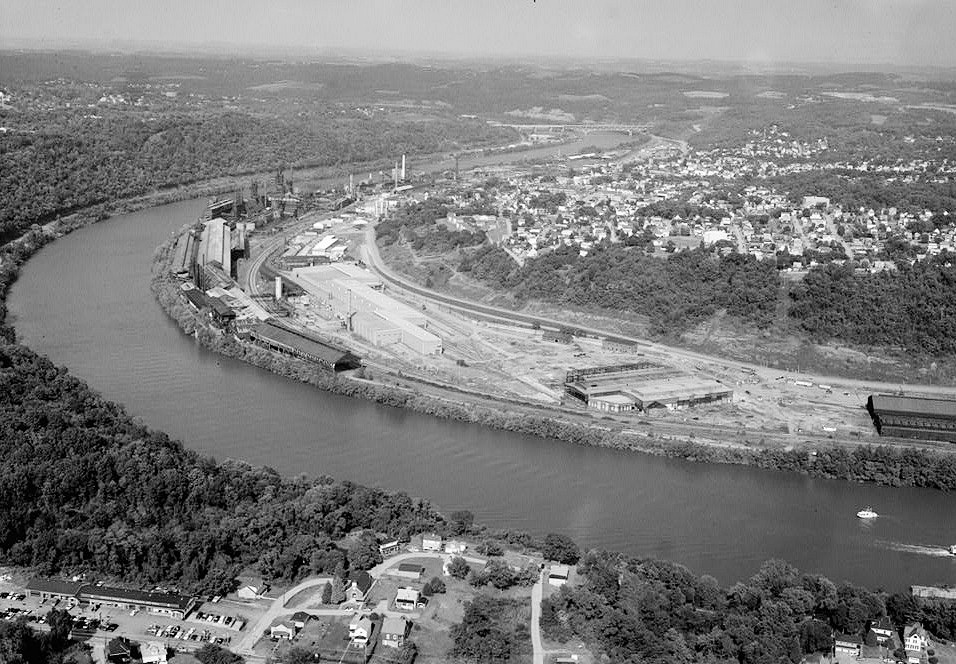 Pittsburgh Steel Company Monessen Works, Monessen Pennsylvania 1995 AERIAL VIEW FACING EAST. VIEW OF FABRIC BUILDING, STRUCTURAL WAREHOUSE, RAIL MILLS & OPEN HEARTH COMPLEX (RIGHT TO LEFT). CITY OF MONESSEN IN BACKGROUND.