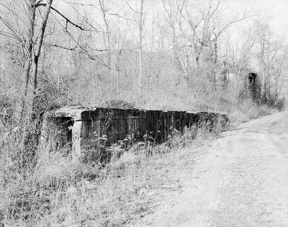 Tower Hill 2 Mine & Coke Ovens, Tower Hill Pennsylvania VIEW OF A HEATING DUCT SITUATED SOUTHWEST OF THE FAN HOUSE, ALONG THE MINE ROAD. THE BURNED RUINS OF THE MINE OFFICE ARE LOCATED 0N THE FAR SIDE OF THE HEATING DUCT, TO THE NORTHWEST
