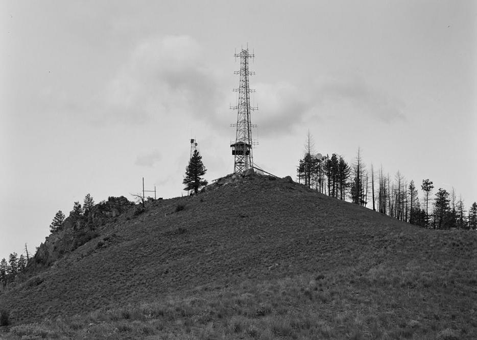 Chelan Butte Lookout - Fire Watchtower, Chelan Washington 1995 View from ridge running S from summit shows profile of summit area and south elevation of lookout tower.  The tower is partially obscured by a cellular telephone communications tower.