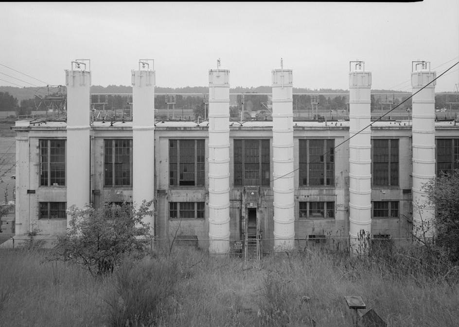 Puget Sound Power & Light Company, White River Hydroelectric Project, Dieringer Washington East facade of powerhouse, showing rear door of the building; the steel tanks adjacent to the powerhouse are surge tanks, each penstock has two surge tanks; looking west (1989)
