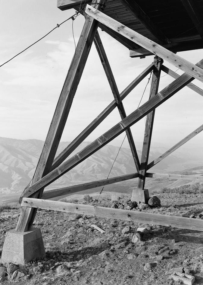 Badger Mountain Lookout Fire Watchtower, East Wenatchee Washington 1994 Detail of tower support construction shows two legs, cross beams end concrete point load footing on west side.  Camera is pointed NW.
