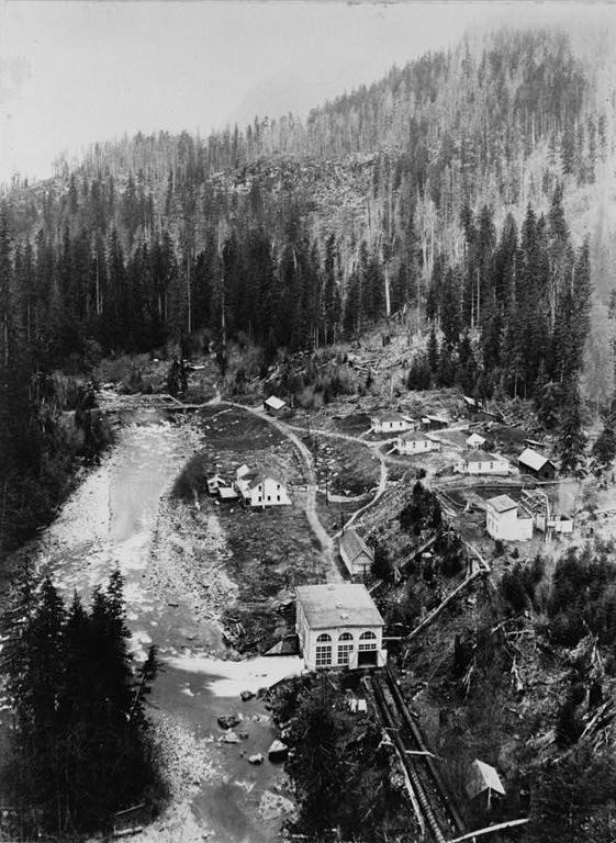 Nooksack Falls Hydroelectric Plant, Glacier Washington Historic overview of newly completed powerhouse and company houses; looking west. (Photographer unknown, ca. 1906.)