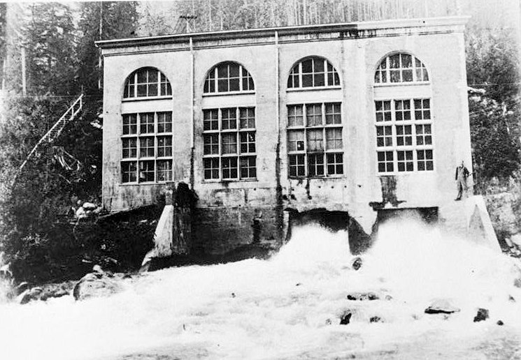 Nooksack Falls Hydroelectric Plant, Glacier Washington Historic overview of powerhouse, company houses, and company hotel, after snowfall; looking west. (Photographer unknown, ca. 1910.)