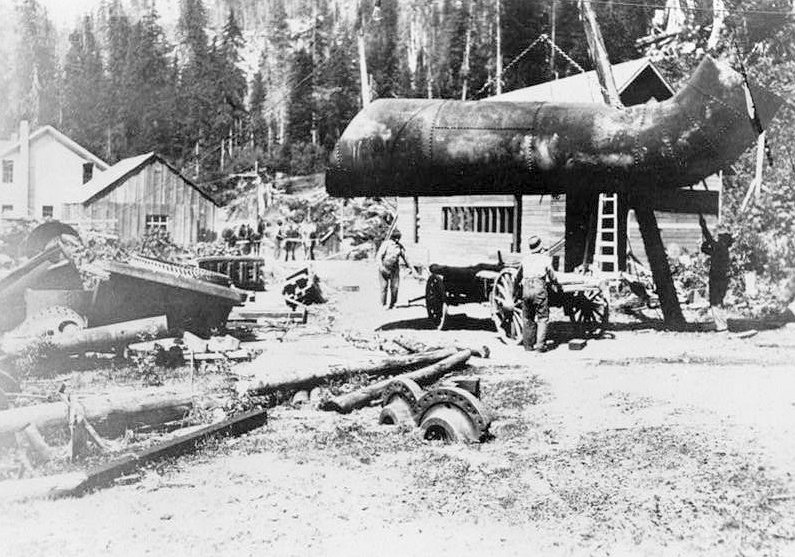 Nooksack Falls Hydroelectric Plant, Glacier Washington Historic view just west of powerhouse during reconstruction of penstocks and replacement of original Francis Turbine with Pelton wheels, in 1912; looking northwest.  (Photographer unknown, ca 1912.)