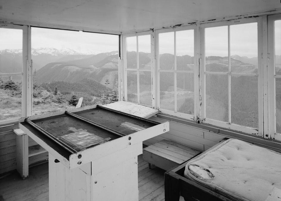 Suntop Lookout Fire Watchtower, Greenwater Washington 1988 INTERIOR, SOUTHWEST CORNER; SHOWING FIREFINDER (FOREGROUND), LIGHTNING STOOL AND BED (BOTH TO RIGHT OF FIREFINDER)