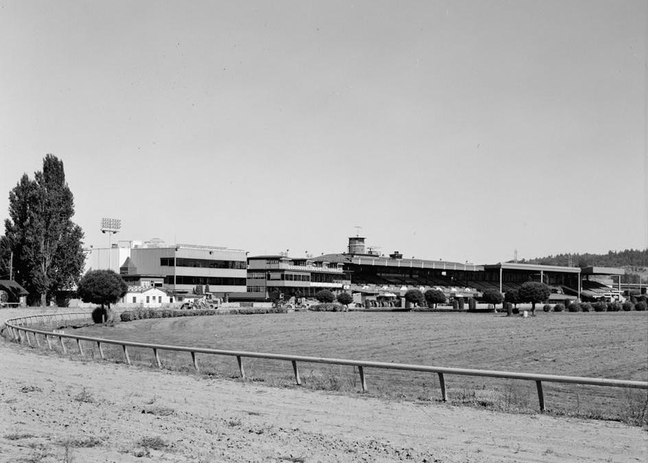 View looking NW showing all major buildings on grandstand side of track, beginning on left with Jockey Building, followed by the Paddock Club, Clubhouse, Original Grandstand, Second Grandstand and North Grandstand. (August 1993)