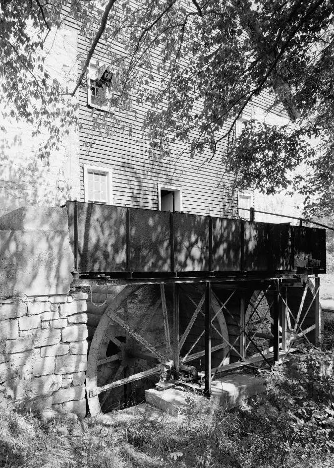 Bunker Hill Grist Mill - Cline and Chapman Roller Mill, Bunker Hill West Virginia View of header box and tandem water wheels from side (1980)