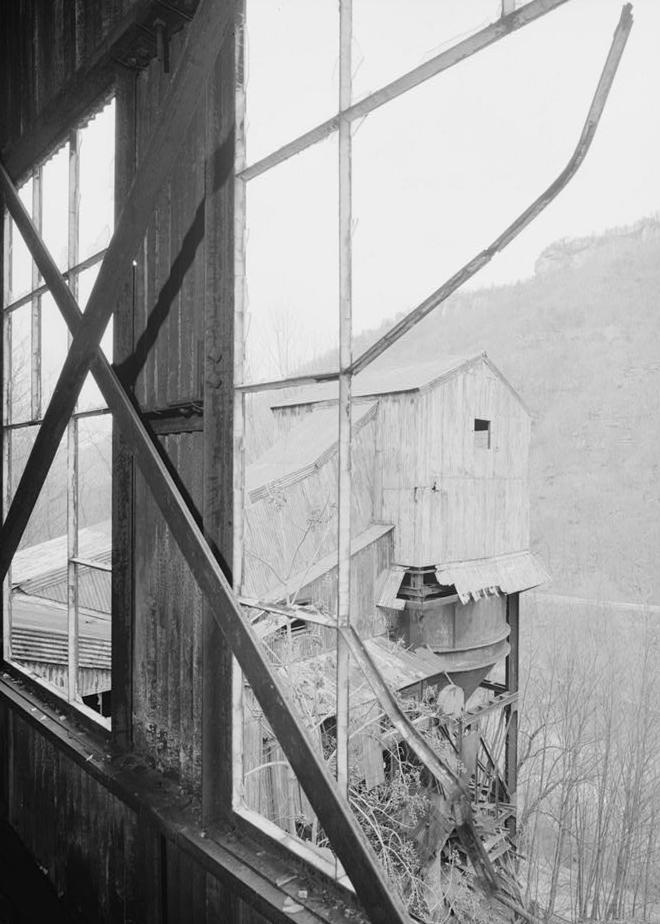 Kaymoor Coal Mine, South side of New River, Fayetteville West Virginia LOOKING OUT UPPER LEVEL WINDOW OF WASH HOUSE SHOWING SLACK COAL STORAGE TANK (1986)
